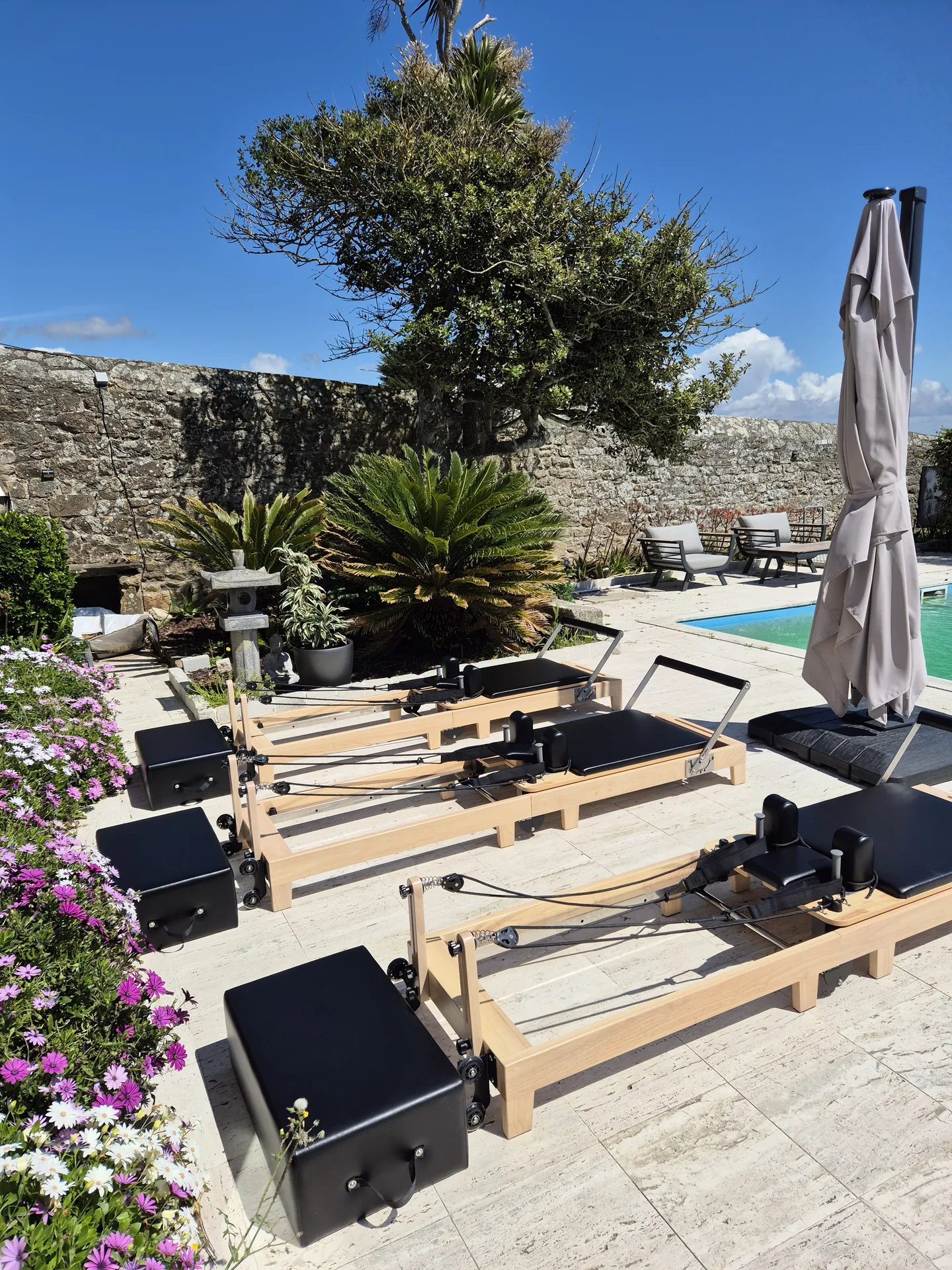 Trois Reformers Pilates en plein air dans un jardin breton